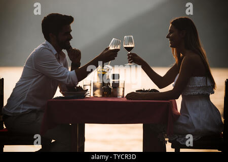 Les gens, les vacances, l'amour et la romance concept. Jeune couple bénéficiant d''un dîner romantique sur la plage. Banque D'Images