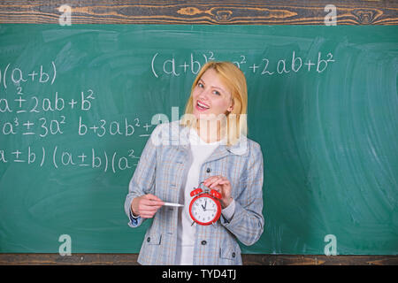 Le temps d'étudier. Enseignants bienvenue année scolaire. À compléter la main-d'œuvre qualifiée enseignante engagée aux éducateurs. La discipline scolaire concept. Enseignant femme tenir réveil. Elle se soucie de la discipline. Banque D'Images