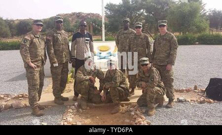 L'équipe du 2e Bataillon, 327e Régiment d'infanterie, de la 1re Brigade Combat Team 'Bastogne', 101st Airborne Division (Air Assault), pose en face de la formation de base des Forces armées nigériennes crest. L'équipe de la Brigade de Bastogne a passé quatre semaines à observer et faire des recommandations d'amélioration de la formation de base du Niger. Debout de gauche à droite : sgt. 1re classe Michael Mullins, le s.. Cameron Marsh, interprète M. Abdourahmane Ibrahim, le Sgt. 1re classe Elocious Frazier, Sgt. 1re classe Sean Carey, 1er lieutenant Dan Godlasky. À genoux de gauche à droite : Le s.. Matthieu Banque D'Images