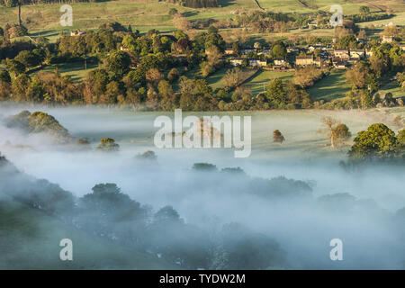 La vue à travers un brouillard rempli de Tees Valley Crag Sifflet vers le village de Mickleton Teesdale, County Durham, Royaume-Uni Banque D'Images