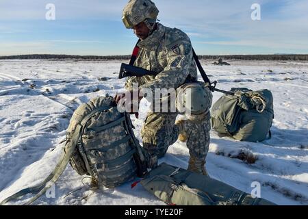 Le sergent de l'armée américaine. Kofi Latiff, originaire de Brooklyn, NY, affecté à la Compagnie B, 6e bataillon du génie de la Brigade (Airborne), 4th Infantry Brigade Combat Team (Airborne), 25e Division d'infanterie de l'armée américaine en Alaska, assure son sac à dos après un saut d'entraînement en vol d'un hélicoptère CH-47 Chinook sur Malemute drop zone at Joint Base Elmendorf-Richardson, Alaska, le Jeudi, Novembre 3, 2016. Les soldats de 4/25 IBCT appartiennent à la seule brigade aéroportée américaine dans le Pacifique et sont formés pour exécuter les manœuvres dans les conditions climatiques extrêmement froides/environnements de haute altitude à l'appui de combattre, partenaire Banque D'Images