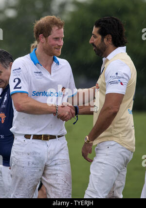 Le Prince Harry de Grande-Bretagne (L), serre la main avec le membre de l'équipe Vaillant Tommy Kato à la fin de la 2016 Sentebale Royal Salute Polo Cup à la vaillante Polo Farm à Palm Beach, en Floride, le 4 mai 2016. Photo par Gary JE Rothstein/UPI Banque D'Images