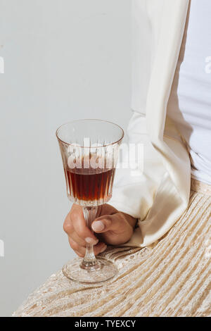 Femme helding une tasse de vermouth italien, un vin blanc fortifié et aromatisé aromatisé avec diverses plantes Banque D'Images