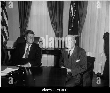 Photographie de l'ex-Président Harry S. Truman, serrant la main de la Première Dame Jacqueline Kennedy lors de son anniversaire dîner à l'armurerie de la Garde nationale à Washington, un dîner a également assisté par l'avocat général Robert F. Kennedy (à droite). Banque D'Images