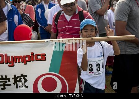 Tomoki, un athlète ayant des besoins spéciaux, contient jusqu'son école signe pour un défilé au cours de la formation d'Olympiques spéciaux Kadena cérémonie d ouverture le 5 novembre 2016, à Kadena Air Base, au Japon. Le KSO rompt les barrières sociales et crée un climat de compréhension et d'acceptation pour les membres de la communauté avec une déficience intellectuelle et physique. Banque D'Images