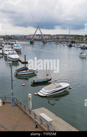 Bateaux amarrés dans le port de Poole avec les deux voiles de levage du pont à Poole, Dorset UK en Juin Banque D'Images