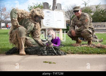 Le Sgt. Robertson (à gauche) et le Sgt. Tarazona, tant en 2e Bataillon, 70e régiment de blindés, 2ème Armored Brigade Combat Team, 1re Division d'infanterie, montrent un Kansas State University Wildcats football fan les outils de leur commerce de sniper lors d'un équipement militaire afficher le 5 novembre à Manhattan, Kansas. KUS a organisé un jeu de reconnaissance pour les soldats et les familles de Fort Riley et le 1er Inf. Div. de construire sur le partenariat continu avec K-State community. (Sgt. Dana Moen, 19e Détachement des affaires publiques) Banque D'Images