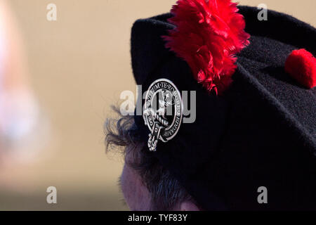 Une femme portant un chapeau de Glengarry traditionnel écossais avec badge et pom rouge Banque D'Images