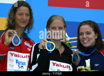 Kirsty Coventry (centre du Zimbabwe) brandit sa médaille d'or gagner du 100 mètres dos course finale au XI CHAMPIONNATS DU MONDE FINA à Montréal, Canada le 26 juillet 2005. Coventry, la médaillée d'argent dans l'événement, a remporté le titre mondial dans un meilleur temps personnel de 1:00.24 devant le champion du monde 2003 Antje Buschschulte (gauche) de l'Allemagne et détenteur du record du monde Natalie Coughlin (droite) d'Emeryville, CA. (Photo d'UPI / Grace Chiu) Banque D'Images