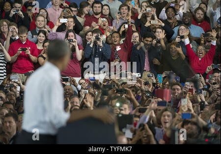 Les membres de l'auditoire applaudir et prendre des photos du président américain Barack Obama qu'il prononce une allocution sur l'emploi et le renforcement de la branche de la fabrication, sur le campus de la NC State University, à Raleigh, en Caroline du Nord, le 15 janvier 2014. Obama annoncer que N.C. L'Université de l'État sera le nouveau domicile à un consortium de 140 millions d'entreprises et d'universités qui mettra au point la prochaine génération de puces électroniques et d'appareils. UPI/Kevin Dietsch. Banque D'Images