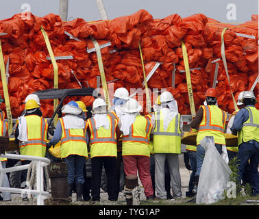 L'huile de vidange des travailleurs de la rampe d'un quai à Hopedale, Louisiane, le 11 mai 2010, que les efforts déployés pour lutter contre l'énorme BP marée noire dans le golfe du Mexique continuent. Pendant que les ingénieurs d'essayer de brancher le bien en eau profonde, les équipes s'emploient à protéger les marais de Louisiane fragile l'étalement lisse. UPI/A.J. Sisco. Banque D'Images