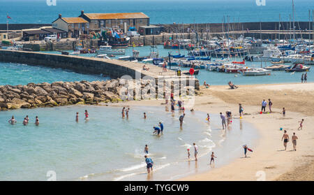 Lyme Regis, dans le Dorset, UK. 26 juin 2019. Météo France : Les visiteurs se prélasser au soleil brûlant à la pittoresque station balnéaire de Lyme Regis cet après-midi. La chaleur les conditions sont définies pour obtenir encore plus chaud et plus humide au cours des prochains jours, comme la "bulle" de chaleur aharan hits le Sud de l'Angleterre. Credit : Celia McMahon/Alamy Live News. Banque D'Images