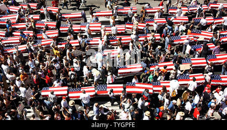 Faux cercueils recouverts du drapeau représentant des soldats américains tués en Iraq sont menées par les manifestants de la 7e Avenue à New York le 29 août 2004, à un rassemblement organisé par les Nations pour la paix et la justice pour protester contre les politiques du président Bush et de la Convention nationale républicaine à New York. (Photo d'UPI/Ezio Petersen) Banque D'Images