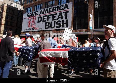 Faux cercueils recouverts du drapeau représentant des soldats américains tués en Iraq sont menées par les manifestants de la 7e Avenue à New York le 29 août 2004, à un rassemblement organisé par les Nations pour la paix et la justice pour protester contre les politiques du président Bush et de la Convention nationale républicaine à New York. (Photo d'UPI/Ezio Petersen) Banque D'Images