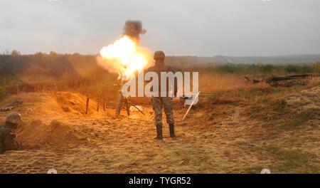 L'viv, Ukraine - Un soldat ukrainien attribué à 1er Bataillon, 80e brigade aéromobile tire un cordon d'un incendie d'une tour de 120 mm Système de mortier, 9 novembre, avant d'une ligne de tir réel de formation des laïcs à l'exercice de maintien de la paix internationale et la sécurité. La formation a été observé ou contrôlé par des soldats affectés au 6e Escadron, 8e régiment de cavalerie, d'infanterie 2e Brigade Combat Team, 3e Division d'infanterie, ainsi que des instructeurs polonais et ukrainien, dans le cadre du Projet conjoint de formation Group-Ukraine multinationales. JMTG-U a pour mission visant à développer des compétences défensives et de l'amélioration de Ukra Banque D'Images