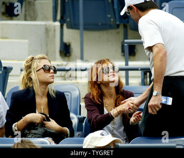 Olson twins Ashley, assis, à gauche, et Mary-Kate, assis à droite, sont accueillis par un ventilateur car ils participent à la demi-finale à l'US Open s'est tenue au National Tennis Center le 11 septembre 2004 à Flushing Meadows, à New York. (Photo d'UPI/Monika Graff) Banque D'Images