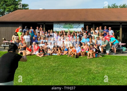 Les adultes et les enfants de différents âges posent pour une photo de groupe lors d'une réunion de famille américaine sur une journée ensoleillée dans le Connecticut, USA. Les participants plus âgés, en général à une réunion de famille sont généralement les grands-parents, parents, frères et sœurs et cousins germains, tandis que les plus jeunes pourraient être deuxième, troisième ou quatrième cousins. Certaines réunions de famille ont lieu sur une base annuelle régulière, ou ils peuvent être des occasions spéciales Tous les 5e ou 10e année ou ainsi. C'est toujours un temps de rencontrer les nouveaux membres de la famille élargie et de partager des histoires, des photos et de l'alimentation. Banque D'Images