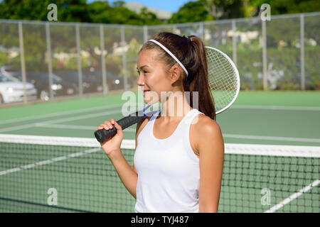 Tennis player portrait avec raquette de tennis en plein air tennis en été. Athlète féminine fit jouer au tennis vivre en santé active sport et style de vie de forme physique. Mixed race caucasienne de l'Asie. Banque D'Images