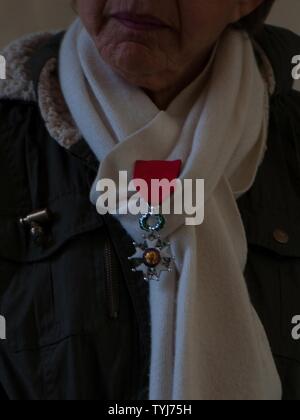 Une femme vous attend pour la cérémonie de dépôt de gerbes de commencer à la Lorraine Cimetière Américain d'honorer les anciens combattants de la guerre décédé le 11 novembre 2016, à Saint Avold, France. Épinglé à son écharpe est son mari décédé de la Légion du Mérite, la médaille décernée aux militaires pour conduite particulièrement méritoire dans l'exercice d'éminents services et réalisations. La journée est célébrée chaque année le 11 novembre commémore les anciens combattants et militaires qui servent actuellement ou ont servi les forces armées des États-Unis, y compris ceux qui ont donné l'ultime sacrifice. Selon l'Administration des anciens combattants et, s Banque D'Images