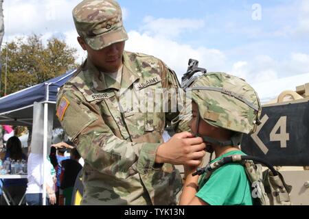 SAN ANTONIO- SPC. Ésaïe Strouse, M2 avec équipage de véhicule de combat Bradley Compagnie Bravo 2-5 Cavalry, aide Dillon Kayastha avec équipement de combat d'enfilage à la 1ère pièce de cavalerie au cours de la 'Armée vs match de football irlandais le 12 novembre 2016. Dillon Kayastha, un natif de New York, rejoint ses parents à l'appui de l'Académie militaire de West Point l'équipe de football. Banque D'Images