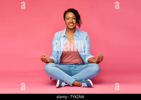 Happy african american woman in lotus yoga pose Banque D'Images