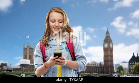 Teen girl étudiant avec sac d'école et smartphone Banque D'Images