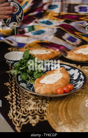 Adjara khachapuri sur la table. l'est dans d'oeufs frais pain chaud sur les plateaux orientaux est dans un restaurant. Banque D'Images