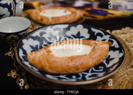 Adjara khachapuri sur la table. l'est dans d'oeufs frais pain chaud sur les plateaux orientaux est dans un restaurant. Banque D'Images