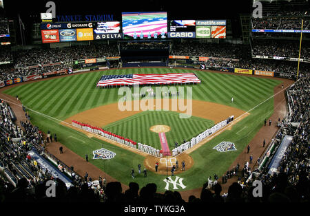Un immense drapeau américain s'affiche dans le champ extérieur comme les joueurs forment le long de la ligne de base lors de la cérémonie d'ouverture que les Yankees de New York prendre sur les Phillies de Philadelphie en jeu un des World Series match au Yankee Stadium le 28 octobre 2009 à New York. Photo UPI/Monika Graff Banque D'Images