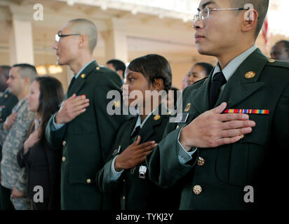 Yong Shin, centre, Kerisha et Rodney Xuran Wu (R), tous les membres de l'armée américaine, saluons le color guard durant la cérémonie de naturalisation qui s'est tenue dans la grande salle sur Ellis Island le 4 décembre 2009 à New York. Plus d'une centaine de personnes de 44 pays ont prêté serment en tant que citoyens au cours de la cérémonie. UPI /Monika Graff Banque D'Images