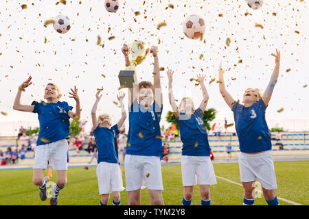 Heureux les garçons célébrant Soccer Championship. Le saut de l'équipe gagnante de football des jeunes et la hausse sur Golden Cup Trophy CÉRÉMONIE Après le tournoi Final Ga Banque D'Images