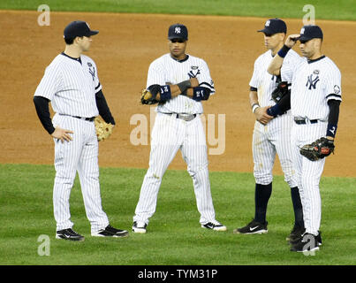 Mark Teixeira (L), Robinson Cano, deuxième à gauche, Alex Rodriguez et Derek Jeter (R) de la Nouvelle York Yankee se tenir autour comme un nouveau lanceur est mis en relief en neuvième manche du match trois au cours de l'ALCS au Yankee Stadium le 18 octobre 2010 à New York. UPI/Monika Graff Banque D'Images