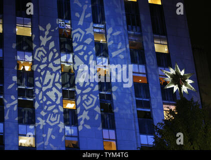 Un flocon design est projetée sur un bâtiment que l'arbre de Noël du Rockefeller Center brille l'étoile de l'éclairage au cours de la cérémonie tenue à Rockefeller Center le 30 novembre 2010 à New York. Le pin norvégien est éclairé par 30 000 lumières LED et sera vue par des milliers au cours de la saison de vacances. UPI /Monika Graff... Banque D'Images