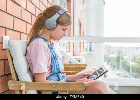 Une jeune fille avec casque de jeu sur tablette Banque D'Images