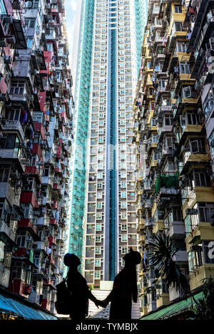 Silhouette d'un couple en face de haute élévation avec beaucoup d'unités à Hong Kong Banque D'Images