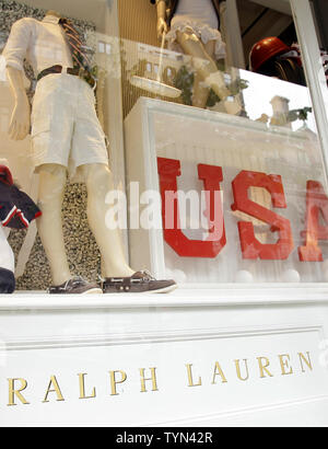 Les piétons marchent par affiche des USA Olympics les vêtements à la boutique Ralph Lauren sur Lexington Avenue à New York le 13 juillet 2012. Plusieurs législateurs, surtout Démocrates, déchargé cette semaine sur le comité olympique américain après les informations selon lesquelles les athlètes américains dans ce ans London Jeux seront tenues d'usure conçu par American Ralph Lauren mais fabriqués principalement en Chine. UPI/John Angelillo Banque D'Images