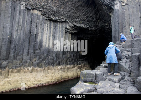 Les touristes à l'entrée de la Grotte de Fingal, sur l'île de Staffa, l'une des Hébrides intérieures Groupe d'îles au large de la côte ouest de l'Écosse. Banque D'Images
