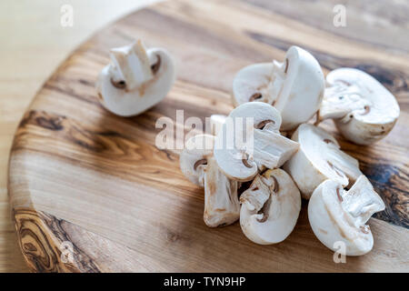 Coupe fermée champignons de close up sur planche à découper en bois Banque D'Images