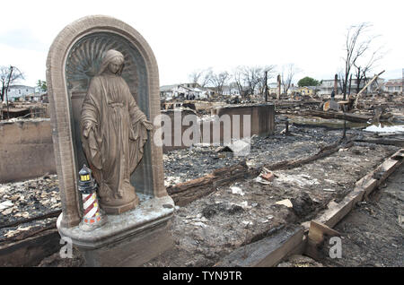 Une statue de la Vierge Marie est parmi les débris carbonisés où quatre-vingts maisons incendiées au sol dans la communauté de Breezy Point dans les quartiers de Queens le 31 octobre 2012 dans la ville de New York. Des vents violents provoqués par l'Ouragan Sandy, deux jours avant l'incendie alimenté alors que de l'eau élevé, il était difficile aux pompiers pour circonscrire le feu. UPI /Monika Graff Banque D'Images