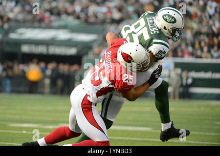New York Jets Chaz Schilens wide receiver (85) porte le ballon pour un gain en cour 3 Arizona Cardinals gratuit à la Kerry Rhodes (25) défend au deuxième trimestre au cours de la semaine 13 de la saison NFL à MetLife Stadium à East Rutherford, New Jersey le 2 décembre 2012. UPI/Riche Kane Banque D'Images