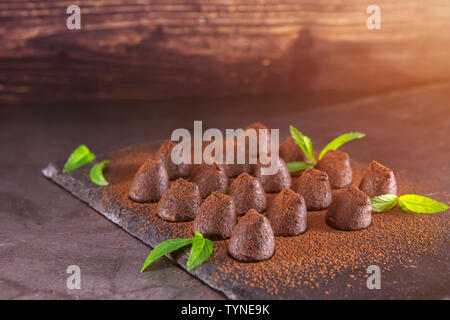 Truffes au chocolat maison à la menthe saupoudré de poudre de cacao sur ardoise. Se concentrer sur les truffes Banque D'Images