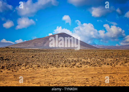 Une vue sur la colline volcanique dans le désert de sable. Ciel bleu avec des nuages est en arrière-plan. Il est situé à Fuerteventura, îles canaries, espagne. Banque D'Images