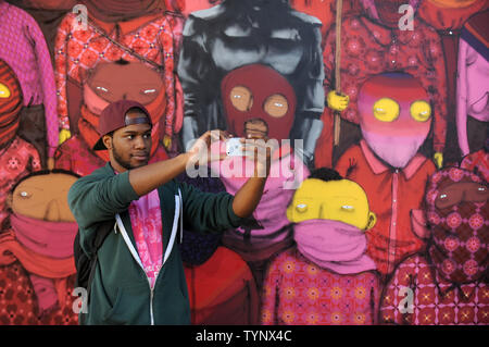 Un homme prend une photo en face d'un espace d'exposition temporaire avec des pièces d'art créées par l'artiste de rue britannique Banksy sur le côté ouest de Manhattan à New York City le 18 octobre 2013. Banksy est un pseudonyme anglaise de l'artiste graffiti, militant politique, réalisateur et peintre. Son art de rue satirique et subversif d'épigrammes combiner l'humour noir avec graffiti fait dans un pochoir. UPI/Dennis Van Tine Banque D'Images