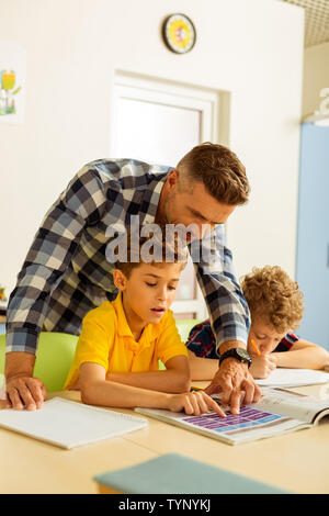 École d'anglais. Cute boy Nice lecture tout en apprenant l'anglais à l'école Banque D'Images