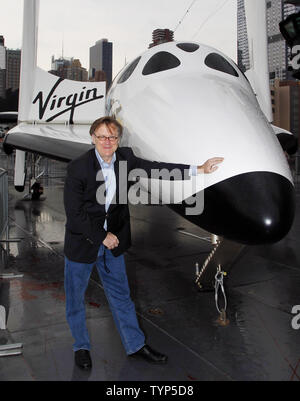 Jim Clash, Virgin Galactic nombre de passagers 610, se tient à côté d'une réplique grandeur nature de la Virgin Galactic SpaceshipTwo, VSS Enterprise spaceship est temporairement sur l'affichage à l'Intrepid Sea, Air & Space Museum de New York City le 22 avril 2014. Le nouveau vaisseau spatial a été mis au point pour le parc de véhicules de Virgin Galactic et est construit pour transporter six clients, ou l'équivalent de la charge utile à la recherche scientifique sur les vols suborbitaux. Les véhicules permettra une expérience de siège avec une vue magnifique sur la planète de le ciel noir de l'espace pour les astronautes de tourisme et de microgravité unique une platfor Banque D'Images