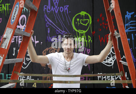 Artiste Gregory prend une pause à Marguerite de peindre une murale sur le site de l'affiche à venir café nommé COFFEED à New York le 16 juillet 2014. Grâce à un partenariat unique avec la charité l'enfant trouvé New York les deux ans détaillant de café COFFEED sera l'ouverture de son premier magasin sur Manhattan Sixth Avenue. UPI/John Angelillo Banque D'Images