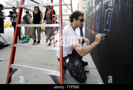 Gregory l'artiste Peintures à Marguerite une murale sur le site de l'affiche à venir café nommé COFFEED à New York le 16 juillet 2014. Grâce à un partenariat unique avec la charité l'enfant trouvé New York les deux ans détaillant de café COFFEED sera l'ouverture de son premier magasin sur Manhattan Sixth Avenue. UPI/John Angelillo Banque D'Images