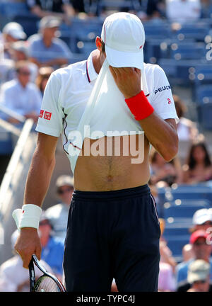 Novak Djokovic la Serbie de l'essuie la sueur sur son visage alors qu'il prend sur Kei Nishikori du Japon dans le quatrième ensemble de leur match de demi-finale à l'USTA Billie Jean King National Tennis Center à New York le 6 septembre 2014. Nishikori, qui 6-4, 1-6, 7(7)-6(4), 6-3, est le premier homme à atteindre l'Asie à l'US Open finales. UPI/Monika Graff Banque D'Images