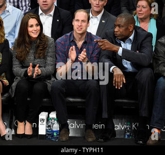 Prince William et Kate, le duc et la duchesse de Cambridge en compagnie de l'ancien grand basket-ball NBA Dikembe Mutombo, droite, regardez les Brooklyn Nets jouer les cavaliers de Cleveland au Barclays Center à New York le 9 décembre 2014. L'horaire des Royals est emballé avec des plans allant du paiement au 11 septembre National Memorial et musée à prendre dans un Cavaliers-Brooklyn. jeu de filets de Cleveland Kate est enceinte de leur deuxième enfant en avril. UPI/Riche Kane Banque D'Images