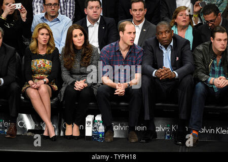 Prince William et Kate, le duc et la duchesse de Cambridge en compagnie de l'ancien grand basket-ball NBA Dikembe Mutombo, droite, regardez les Brooklyn Nets jouer les cavaliers de Cleveland au Barclays Center à New York le 9 décembre 2014. L'horaire des Royals est emballé avec des plans allant du paiement au 11 septembre National Memorial et musée à prendre dans un Cavaliers-Brooklyn. jeu de filets de Cleveland Kate est enceinte de leur deuxième enfant en avril. UPI/Riche Kane Banque D'Images